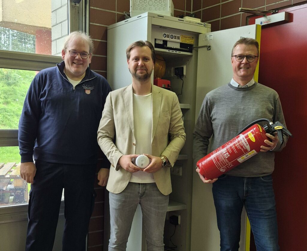 Alexander Schlüter (Leiter der Feuerwehr), Philipp Gürlich (Geschäftsstellenleiter Provinzial Borgholzhausen und Bürgermeister Dirk Speckmann freuen sich über einen der zwei neuen Batterieladeschränke im Hintergrund.