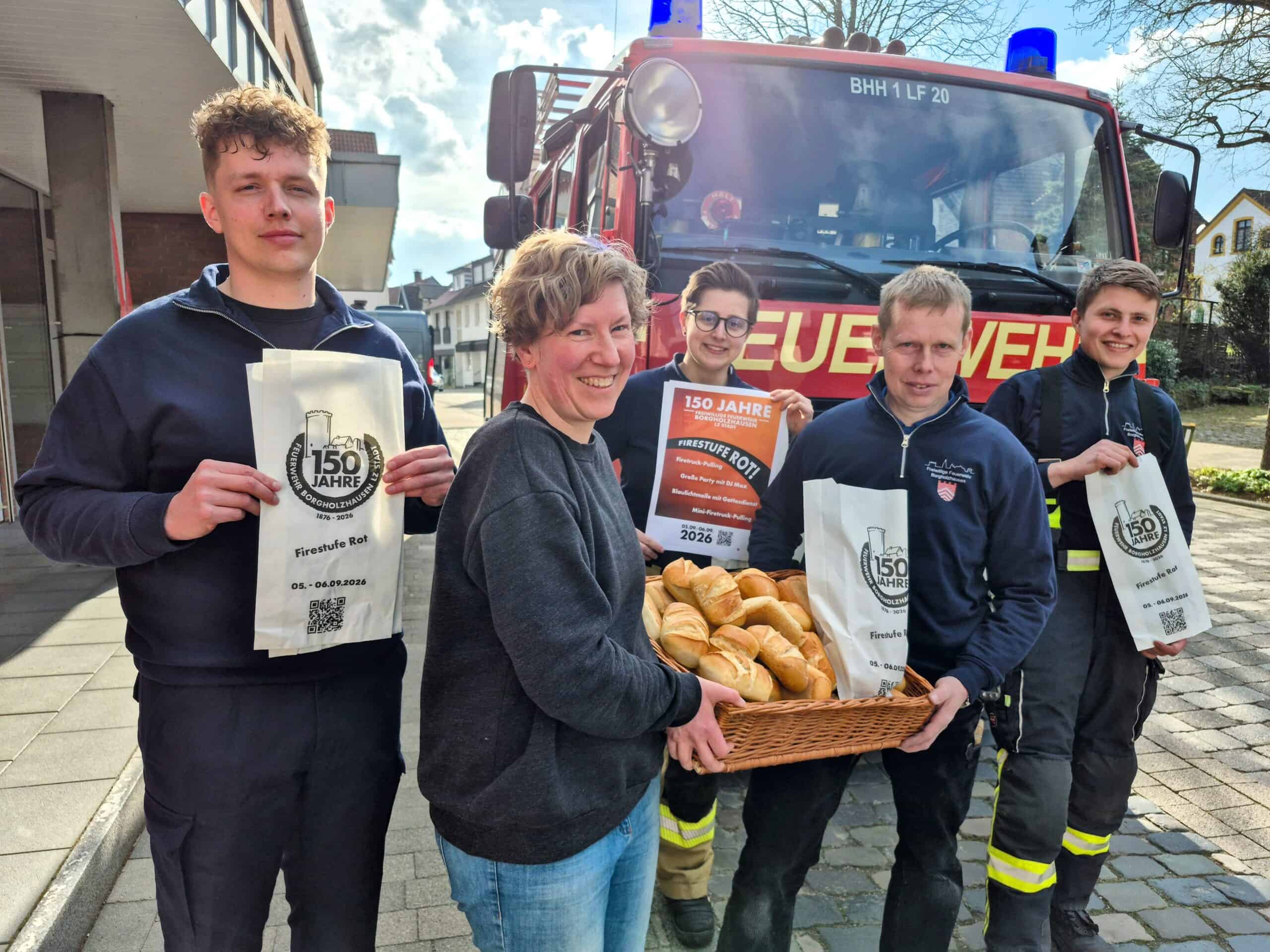 Präsentation der Jubiläums-Brötchentüten vor einem Feuerwehrfahrzeug